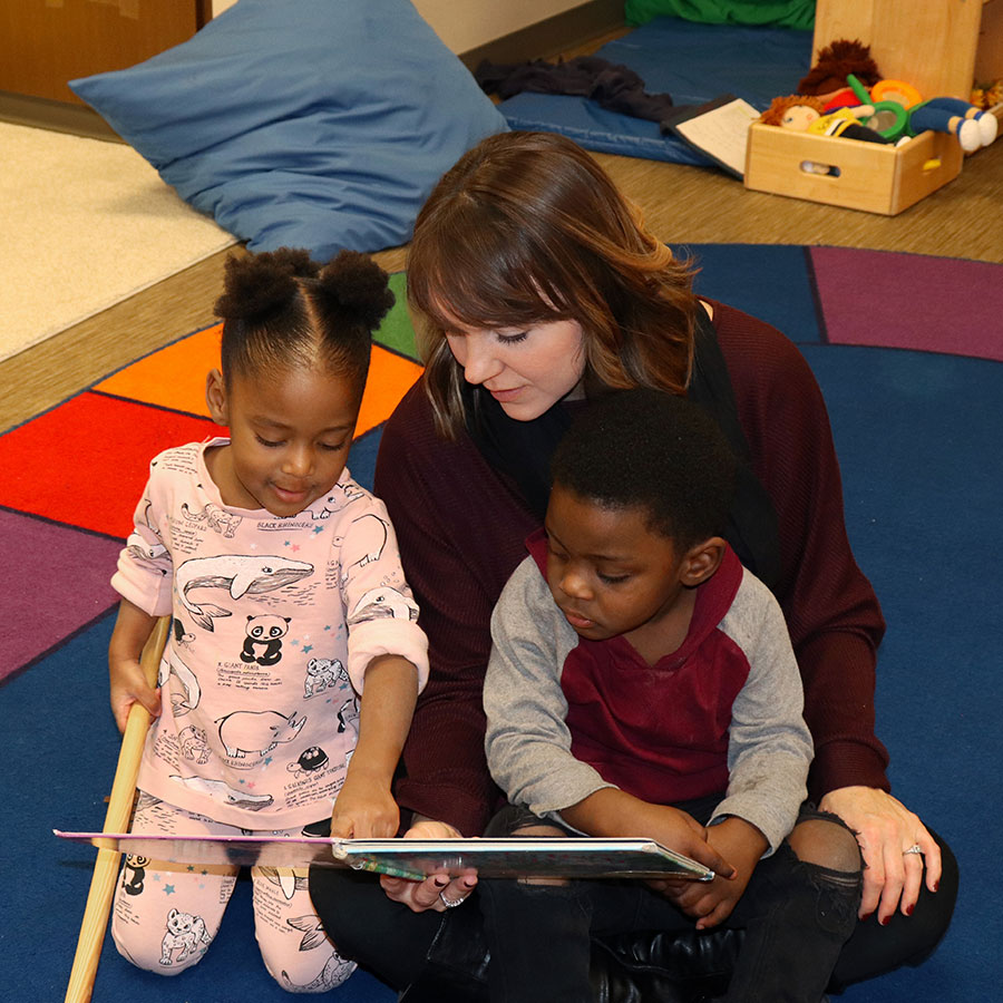 Woman reading a book to children